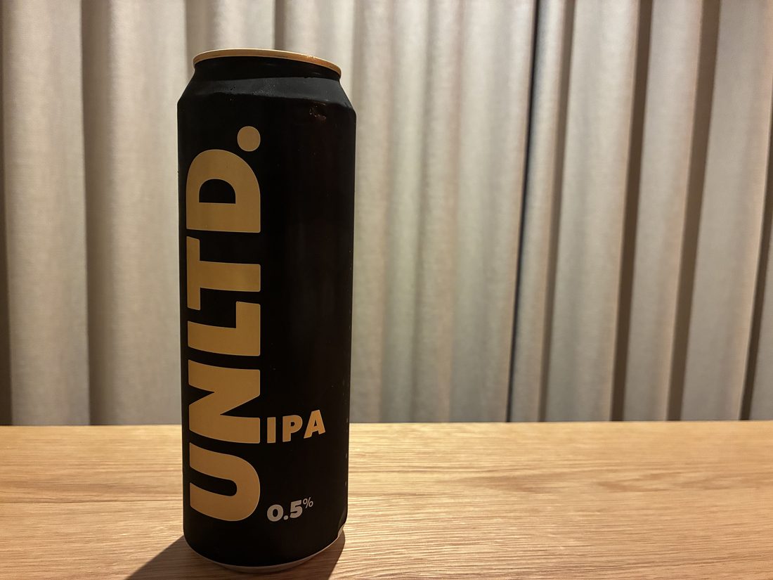A can of UNLTD alcohol-free IPA (0.5%) on a wooden table