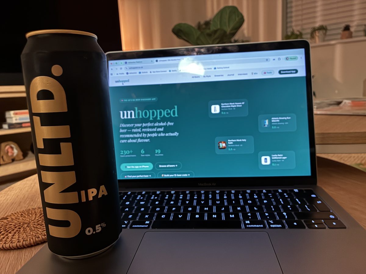 A can of UNLTD IPA beside a laptop showing the Unhopped website